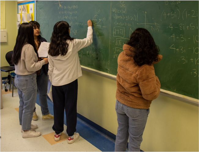 Students solving math problems on the blackboard