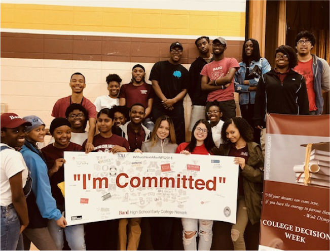 Large group of students holding a "I'm Committed" banner