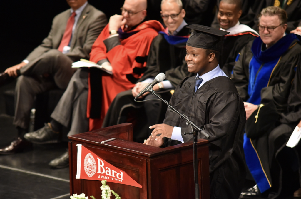 Student smiling at podium on graduation day